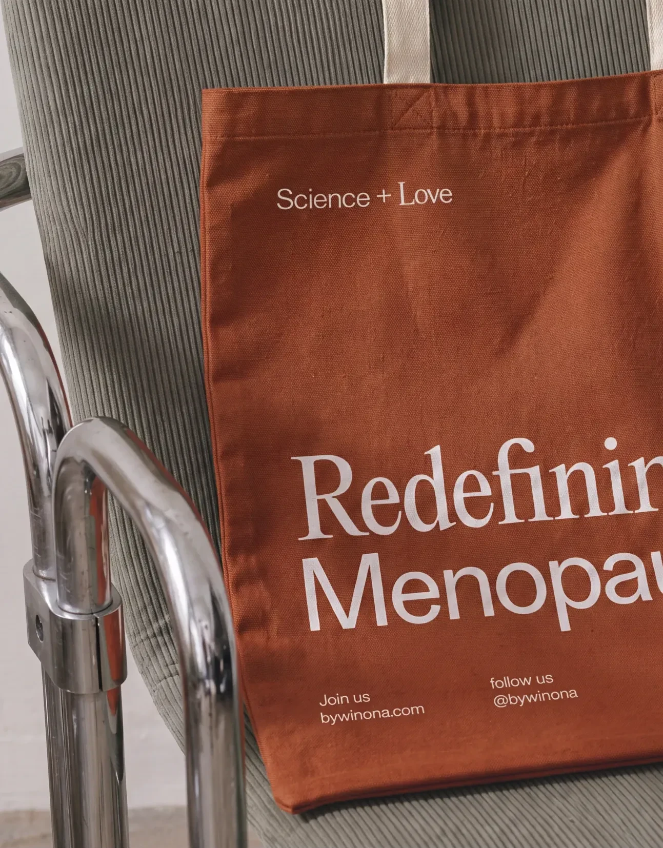 Winona Redefining Menopause tote bag on a chair.