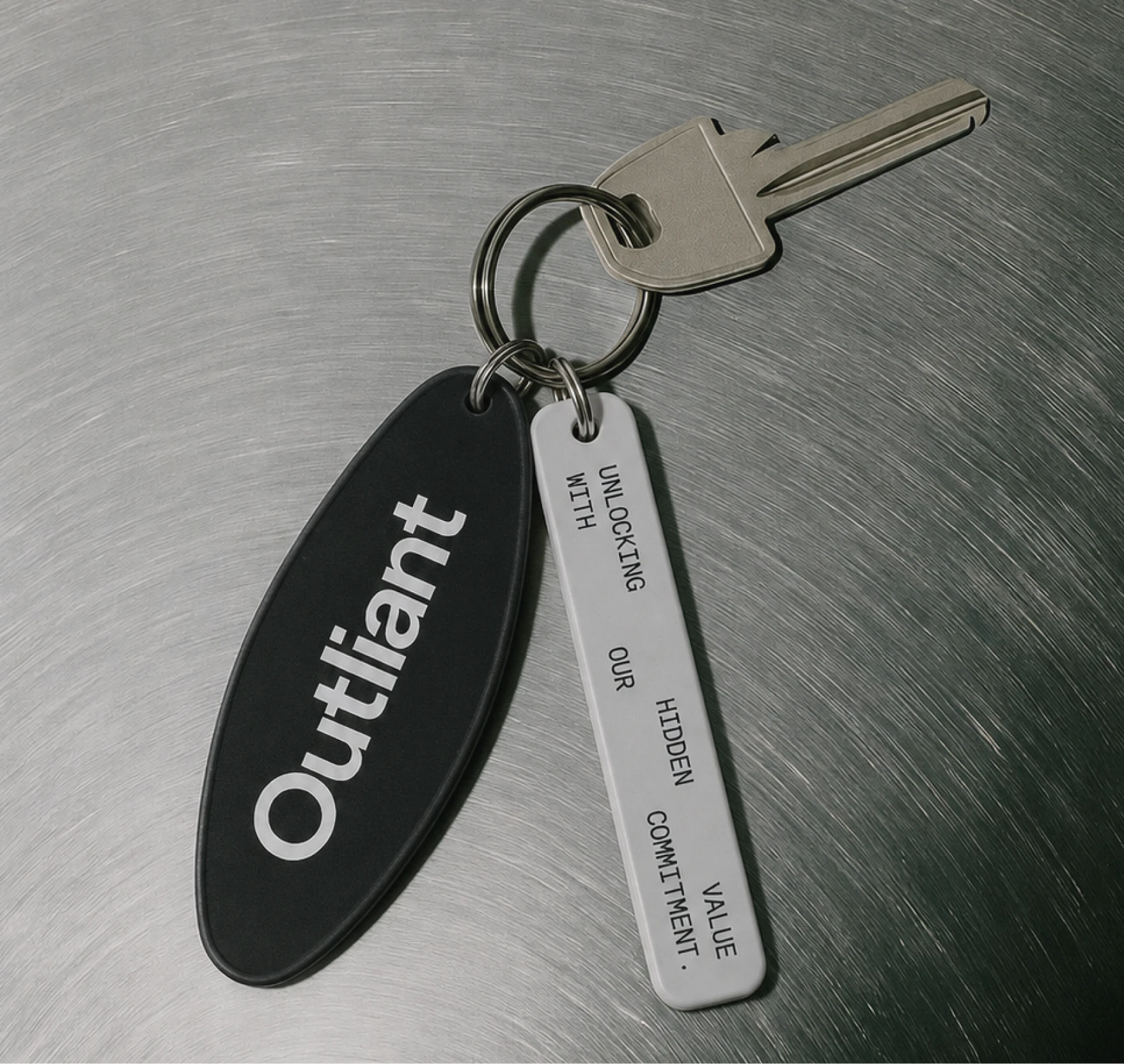 Outliant branded keychain on a metal surface.