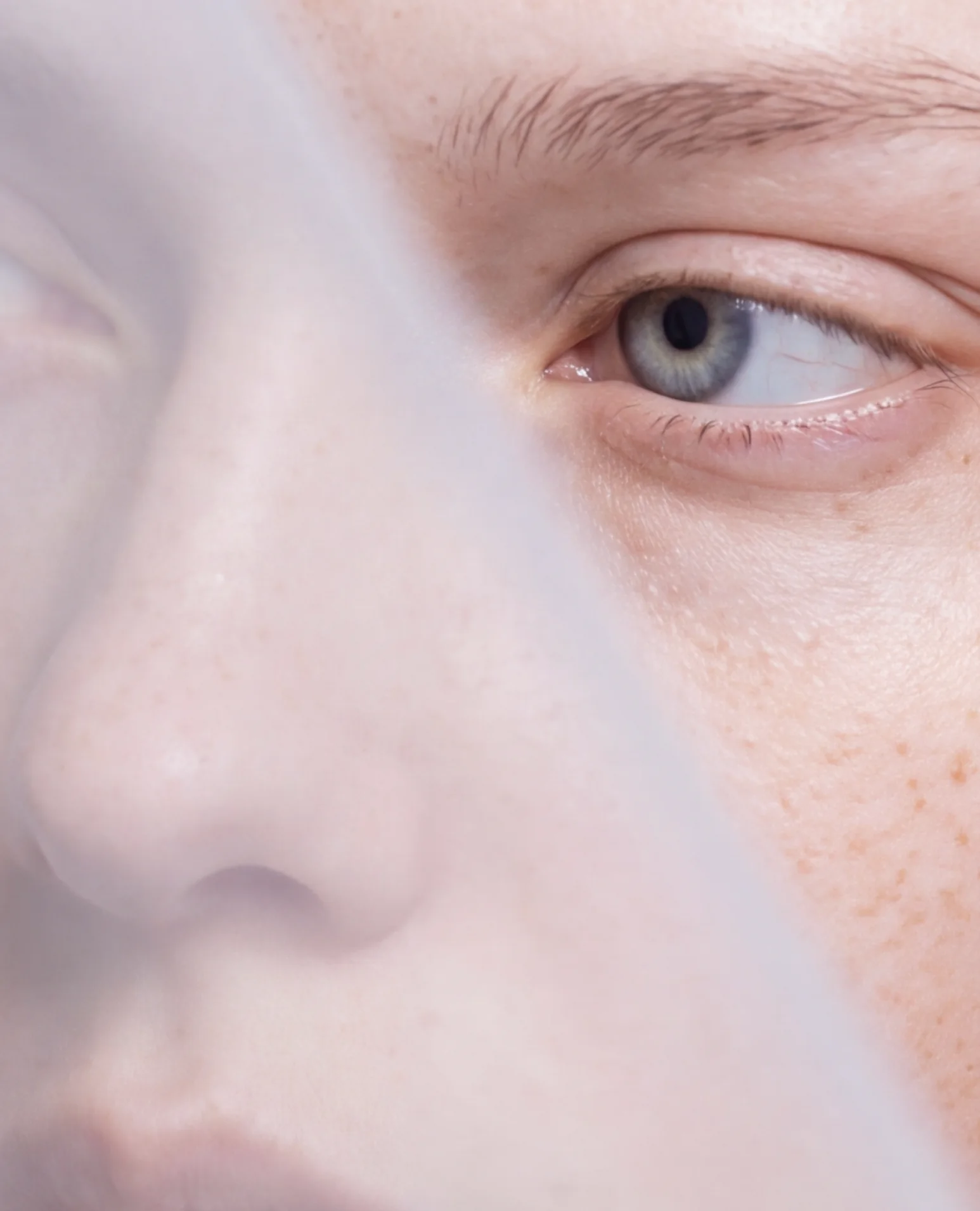 Close-up of an eye and nose behind a translucent veil.