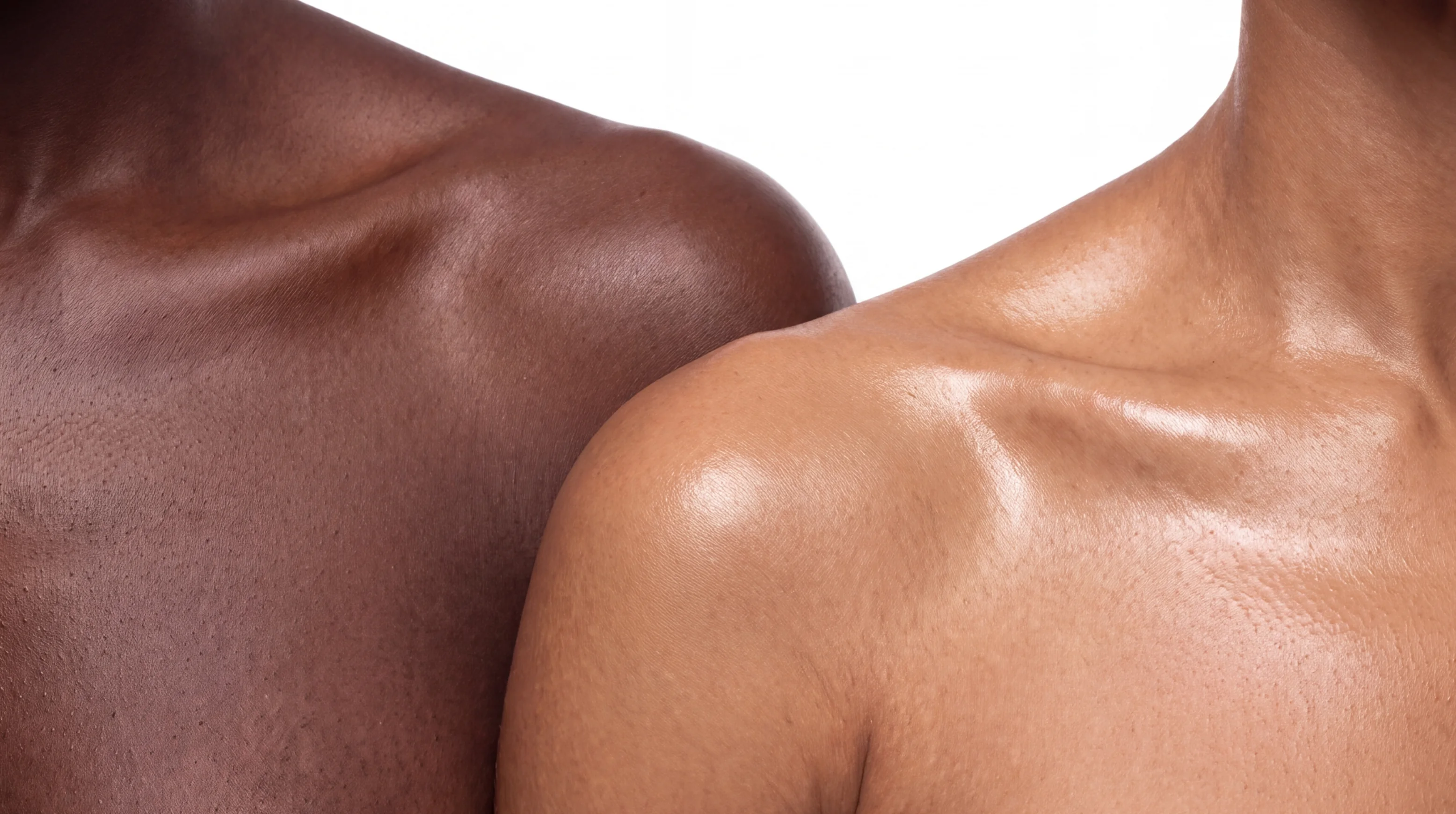 Two glossy bare shoulders, one deep brown and one golden.