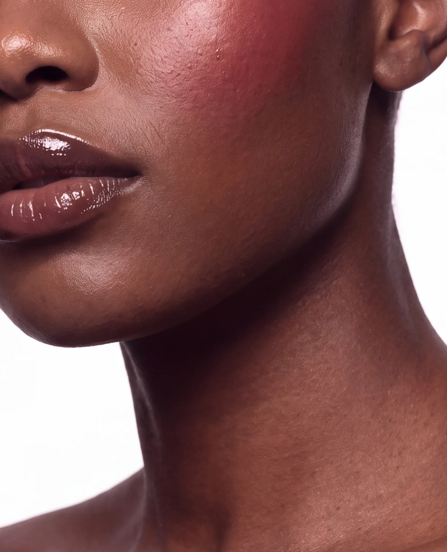 Glossy lips and neck with a soft red blush.