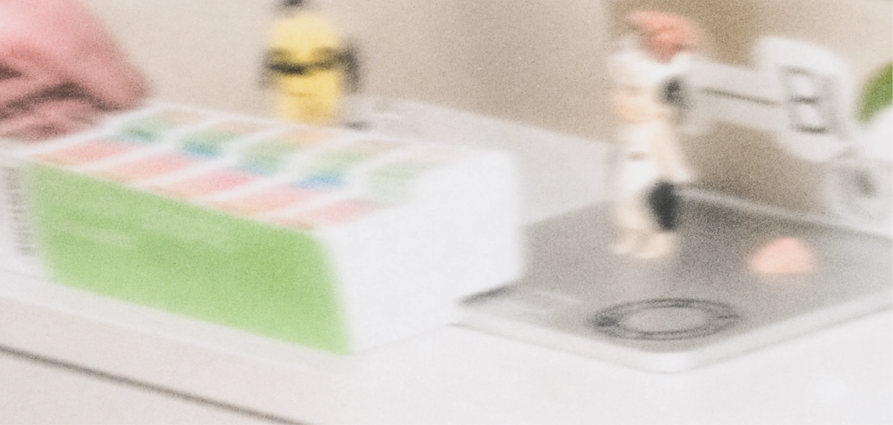 A softly blurred desk with colorful printed materials and design objects.