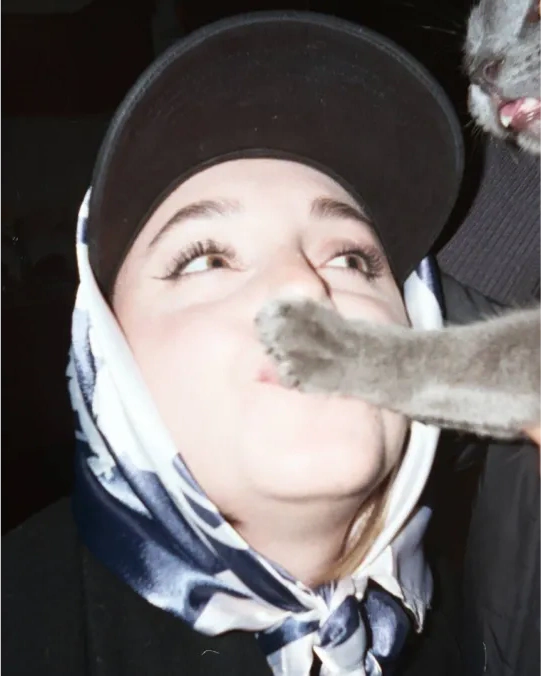 A portrait with a cat paw across the face.