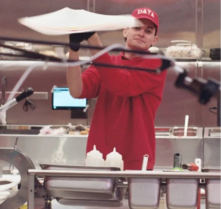 A pizza maker tossing dough.