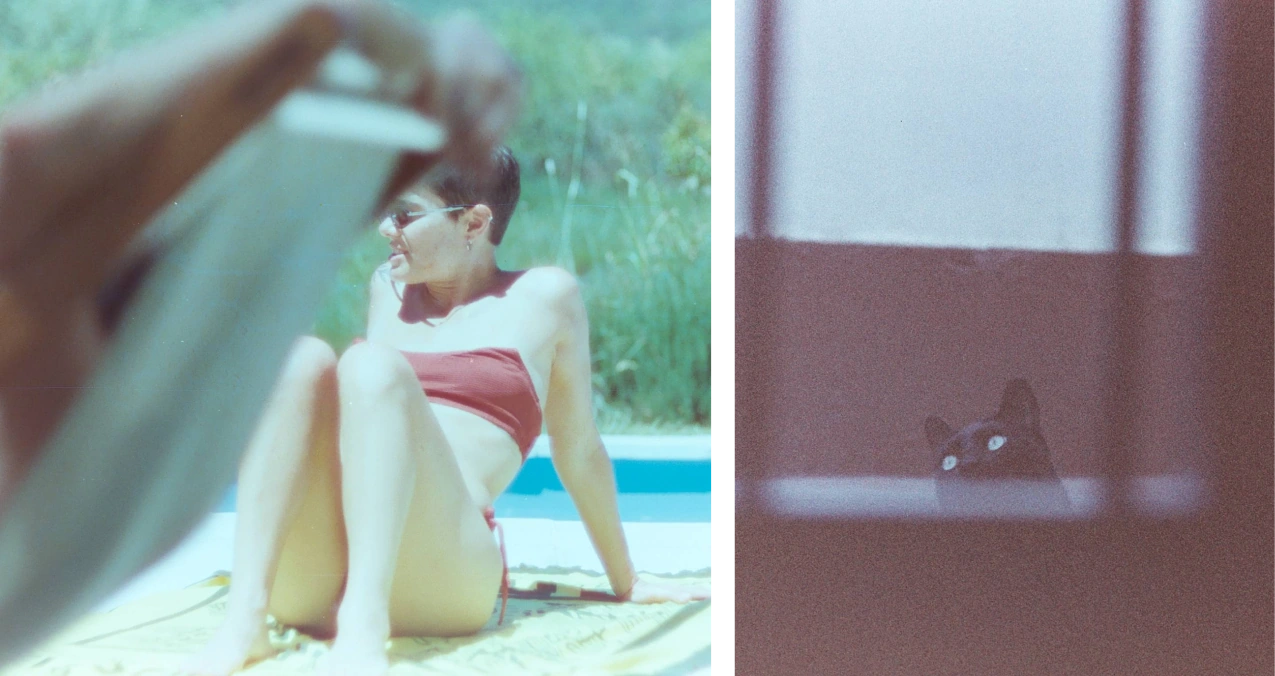 A woman sitting beside a pool beside a black cat peeking above a dark window ledge.