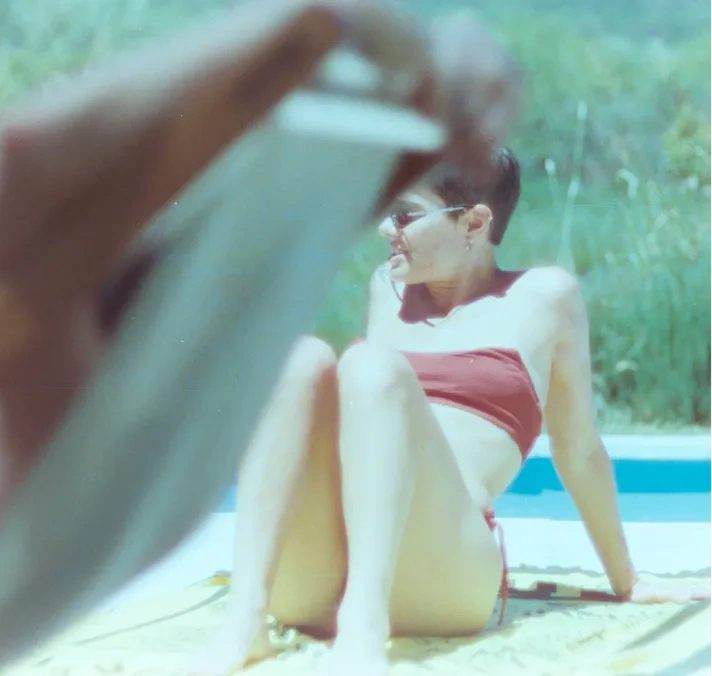 A woman sitting beside a pool.